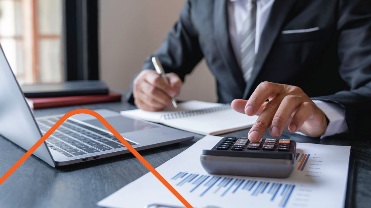 Person taking notes while using calculator